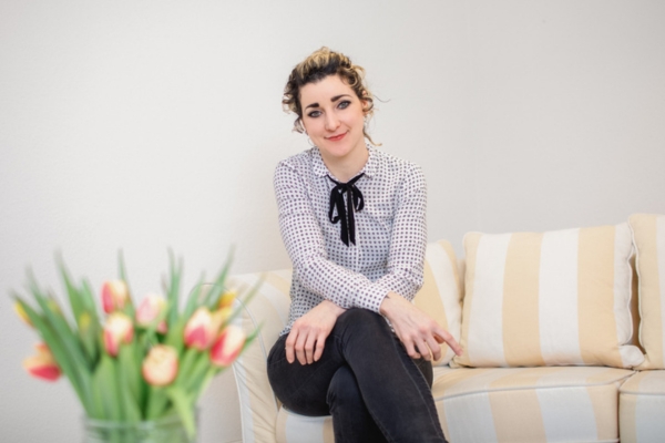 Die Kinder- und Jugendlichenpsychotherapeutin Bernadette Schmidt sitzt auf einem Sofa in ihrer Gemeinschaftspraxis.